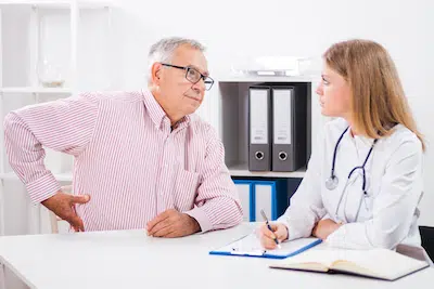 elderly man speaking to his doctor about his back pain