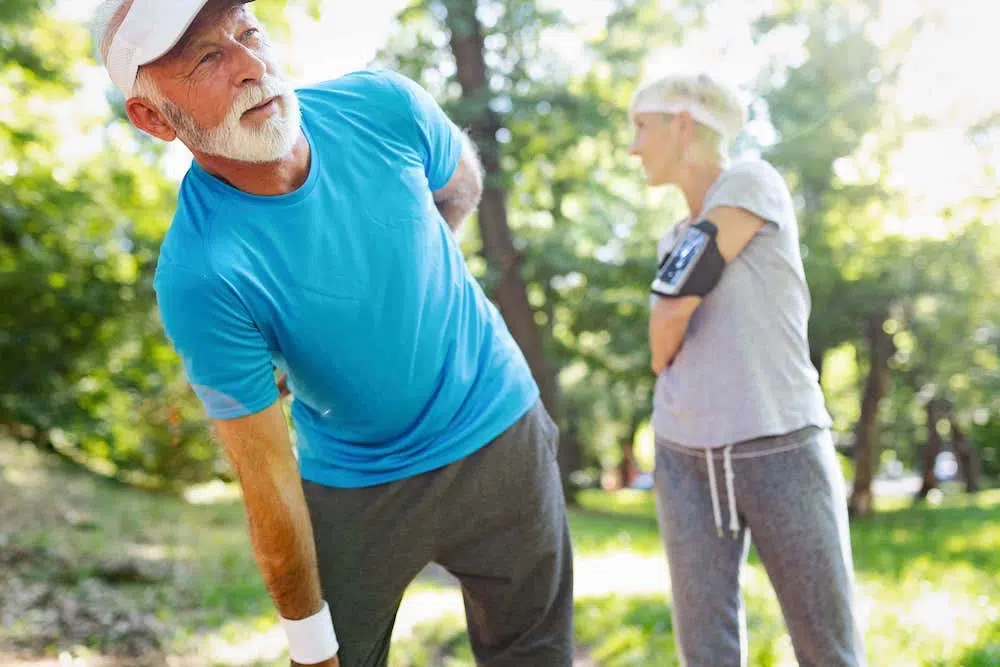 elderly man holding his lower back due to pain