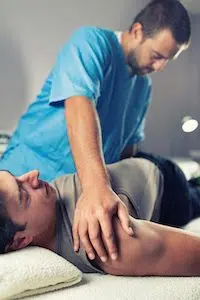 chiropractor adjusting male patients lower back 