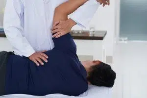 chiropractor adjusting patients shoulder 