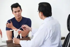 male patient talking with doctor about his shoulder pain