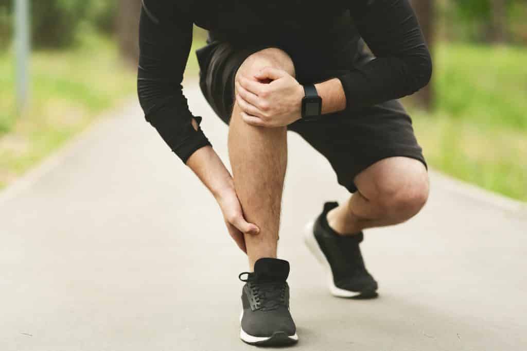 Young male runner is suffering from knee pain