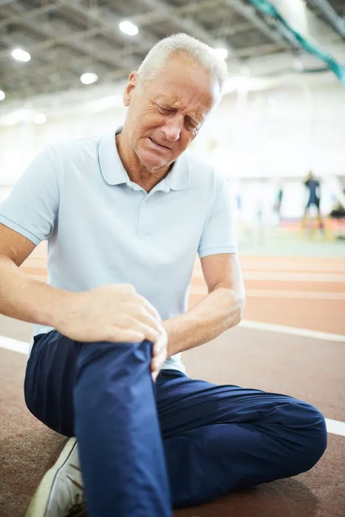 Elderly man holding his knee due to pain