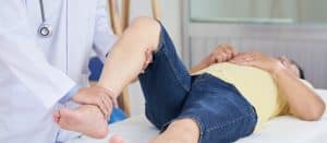 chiropractor examining patients leg