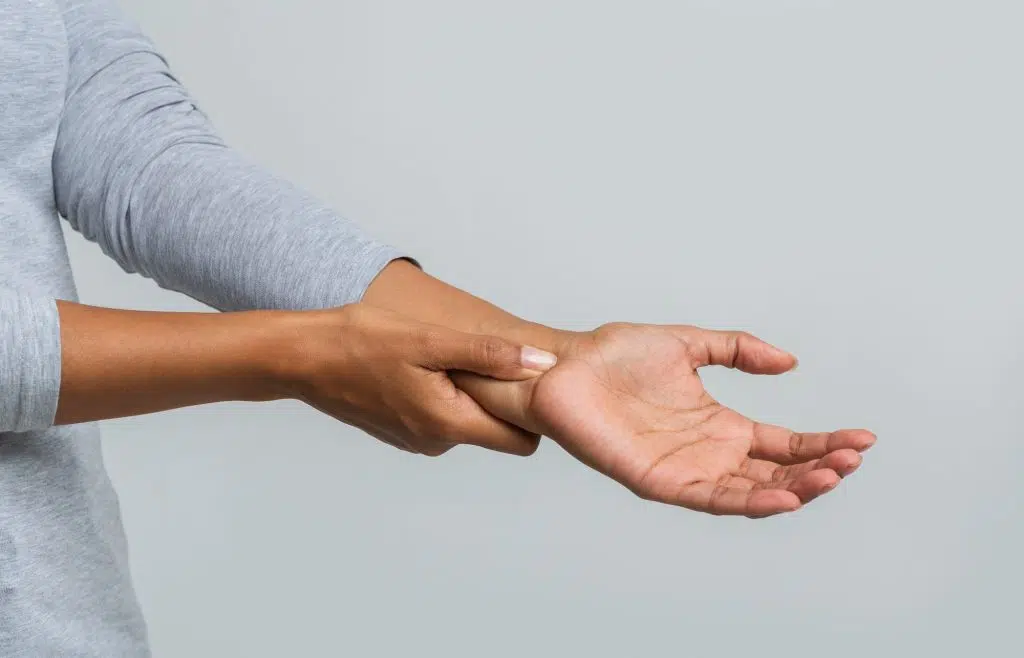 woman holding her hand due to pain