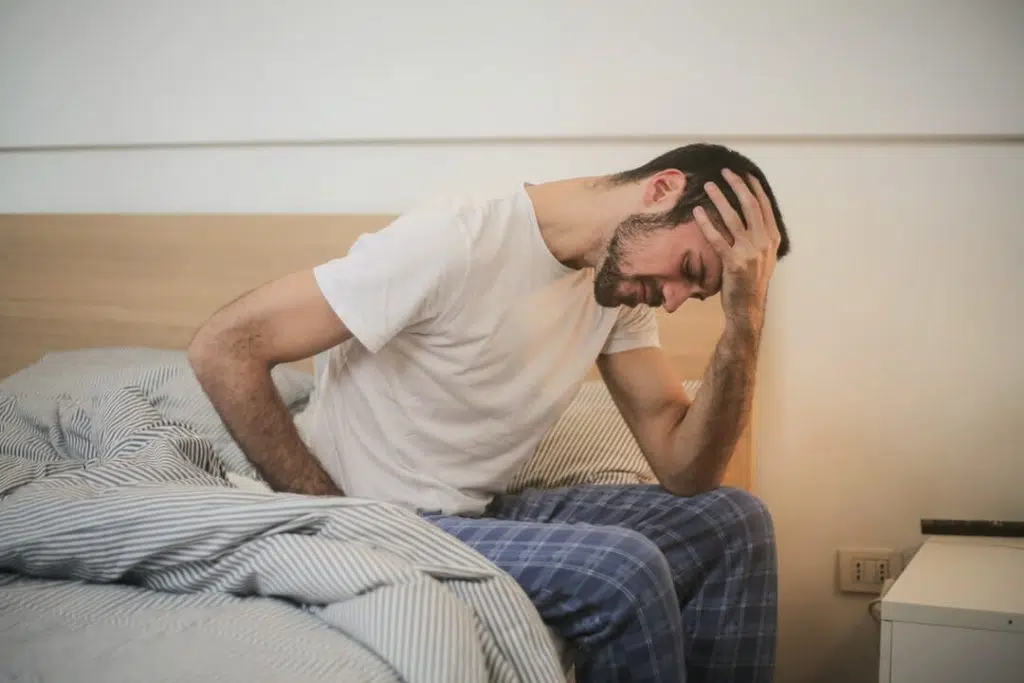 Young man waking tired and having a headache due to fibromyalgia.