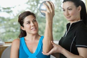 Physical therapist assisting an injury patient in her recovery treatment