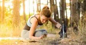 Woman exercising in the woods following recommended corrective exercises
