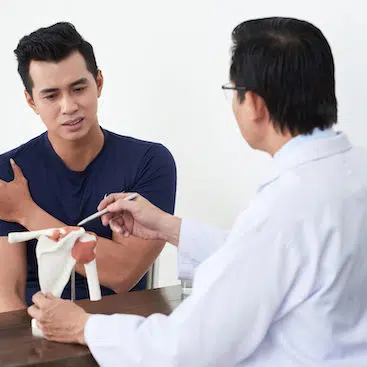 male patient talking with doctor about his shoulder pain
