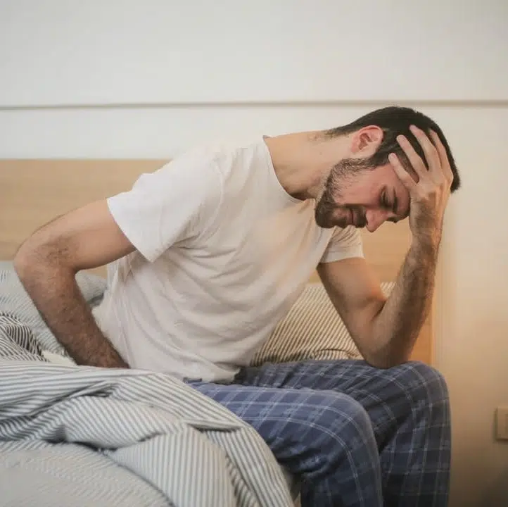 Young man waking tired and having a headache due to fibromyalgia.
