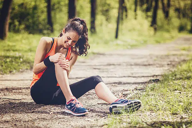 Young woman feeling pain in her knee