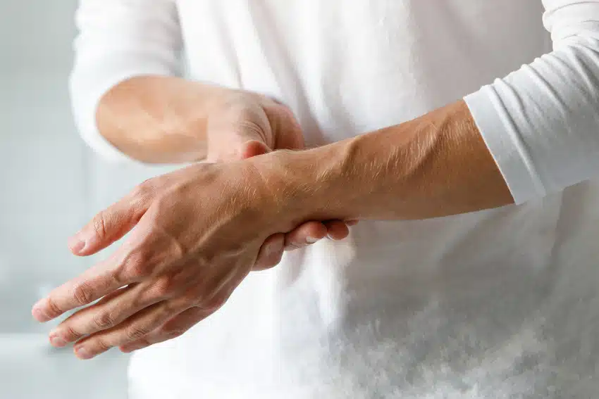 Man holding his wrist feeling of intense pain caused by Carpal Tunnel Syndrome.