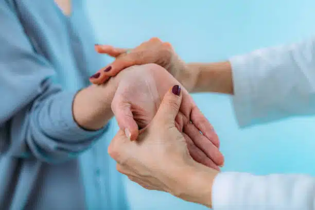 Chiropractor doing some adjustment to the hand of senior patient with pain in wrist. Carpal tunnel syndrome.