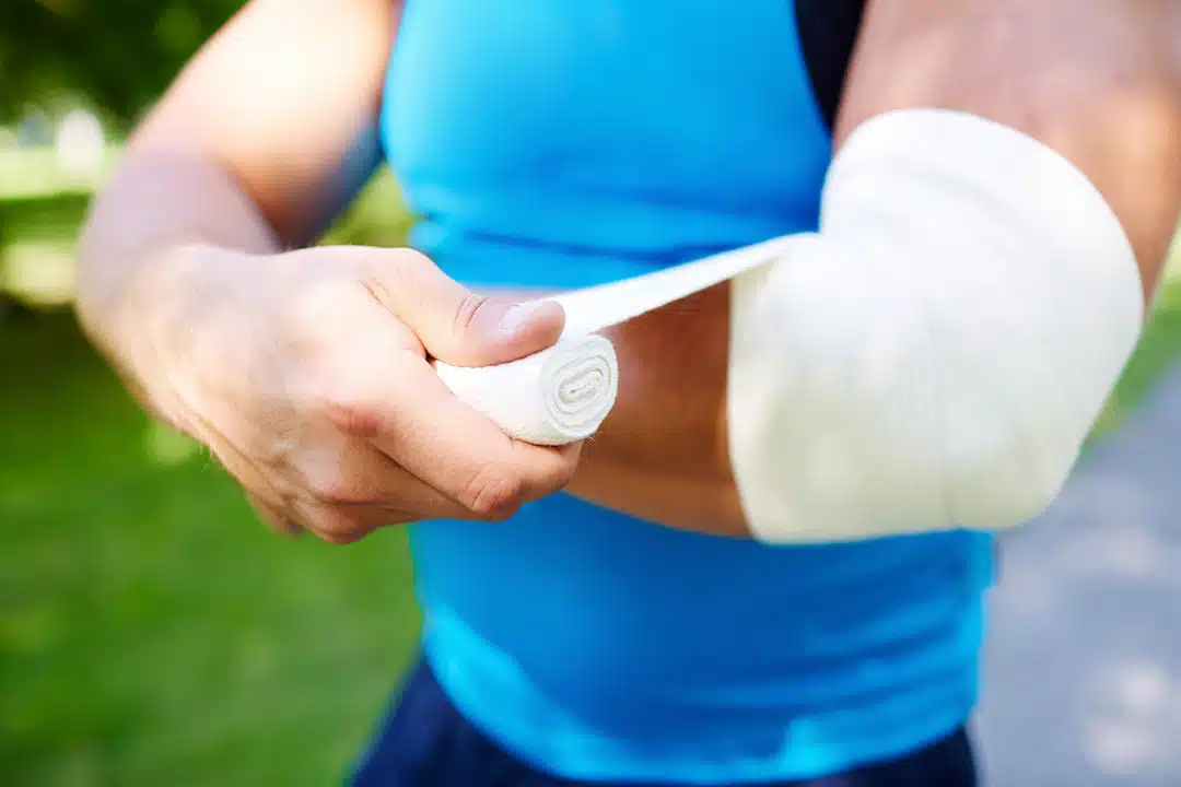 bandaging an arm after acquiring sprain from personal injury