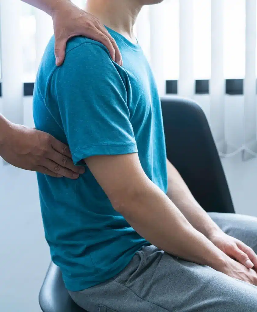 man with Back Pain at the clinic for chiropractic care in aurora consultation