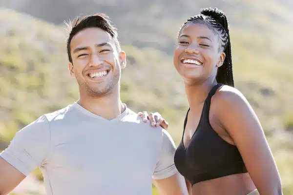 Physically and emotionally fit couple smiling at the camera for chiropractic care in aurora
